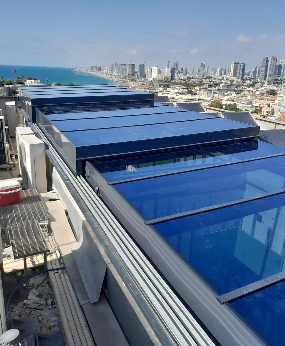 סקיילייט נוסע תלת־שלבי על גג הפנטהאוז, מול הים וקו הרקיע של תל אביב